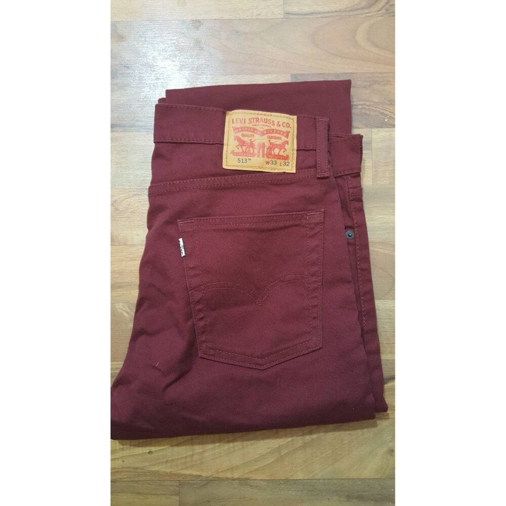 Burgundy Levi 513s. 5 pocket styling, boot cut, zip/button fly. Size 33x32.